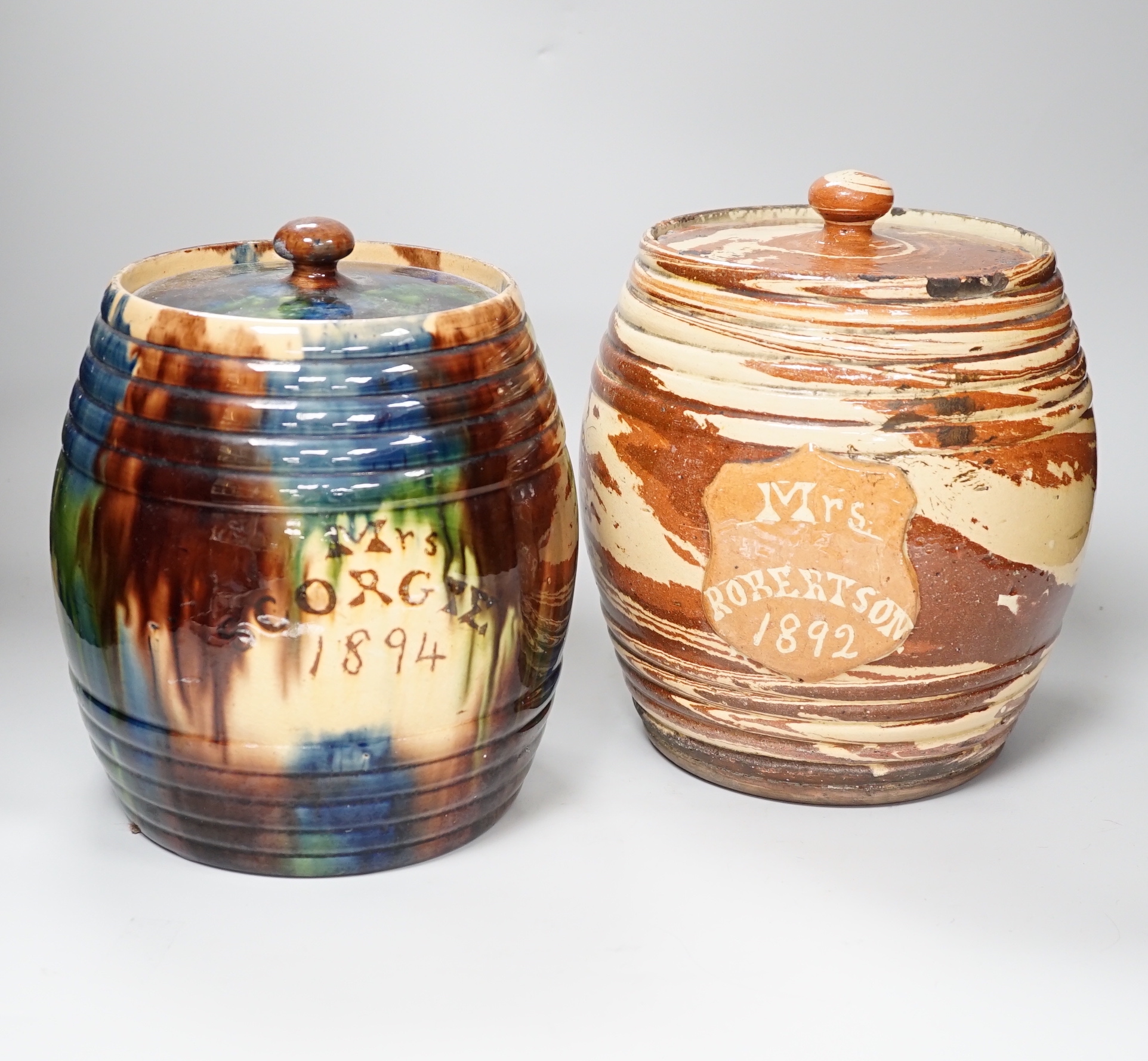 A Victorian Scottish Seaton pottery agate earthenware barrel shaped storage jar and cover, inscribed Mrs Robertson 1892 and another mottle glazed inscribed ‘Mrs Scogie 1894’, 25cm